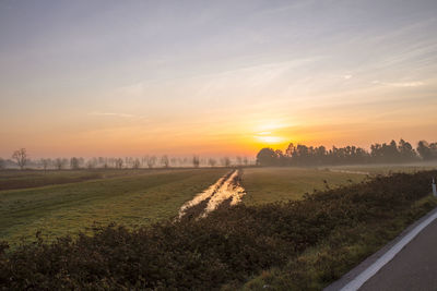 Scenic view of field against sky during sunset