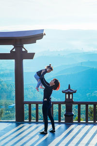 Side view of woman playing with daughter at observation point