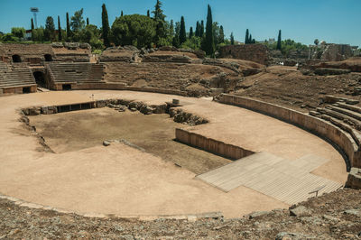 Stone bleachers and arena in the roman amphitheater at the archaeological site of merida, spain.