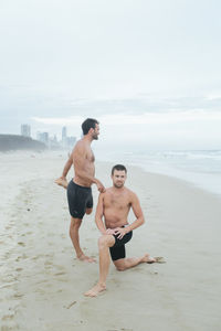 Men stretching on beach