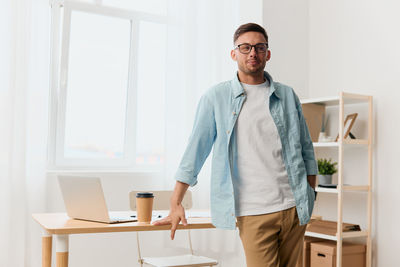 Portrait of young man standing in office