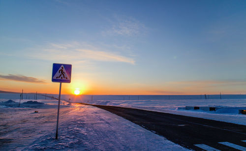 Empty road along snow covered landscape