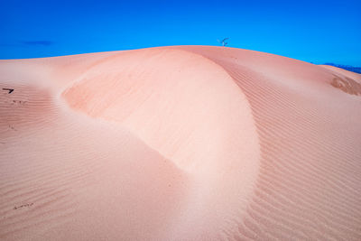 Scenic view of desert against clear blue sky