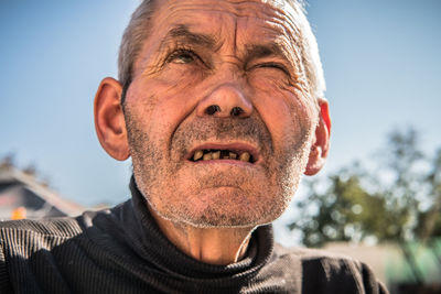 Close-up portrait of man wearing mask against sky