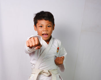 A child is demonstrating a martial arts punch