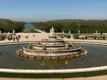 Statues in water fountain against sky