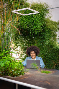 Woman using laptop while sitting on table