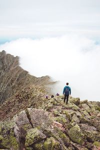 Rear view of man at mountain against sky