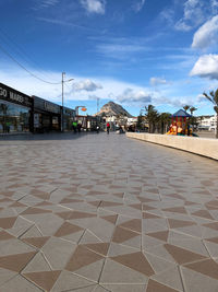 Surface level of footpath by buildings against sky