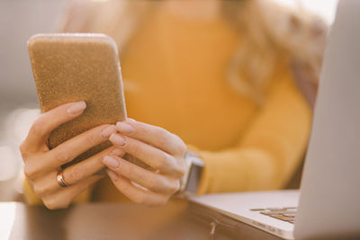 Midsection of woman using mobile phone