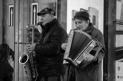 Young man holding camera while standing outdoors