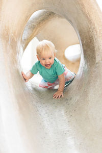 Child playing on outdoor playground. toddler plays on school or kindergarten yard. active kid on