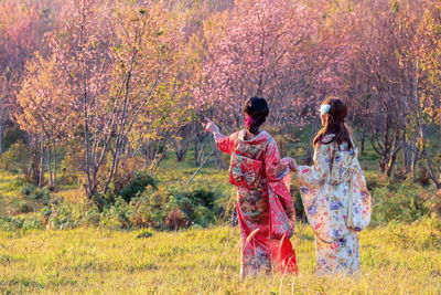 Friends standing in forest during autumn