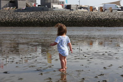 Rear view of toddler walking on beach