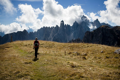 Rear view of woman walking on mountain against sky