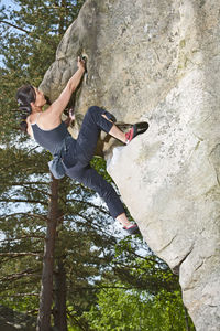 Mature woman bouldering in the forest of fontainebleau close to paris