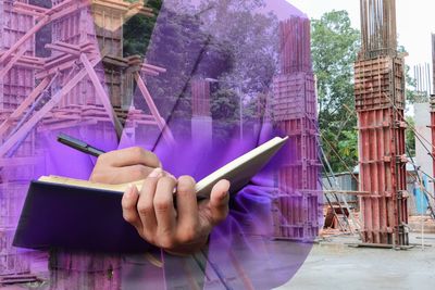 Digital composite image of man using mobile phone against building