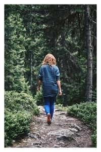 Rear view of woman walking in forest