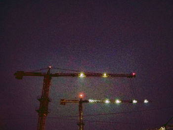 Low angle view of illuminated bridge against sky at night