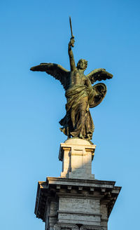 Low angle view of statue against blue sky