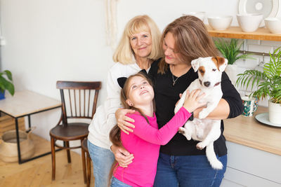 Portrait of smiling young woman with dog at home