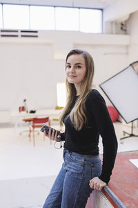 Side view portrait of confident woman standing in office