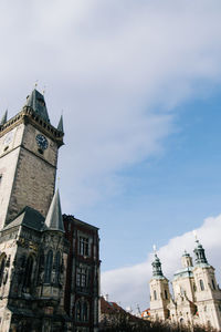 Low angle view of clock tower against cloudy sky