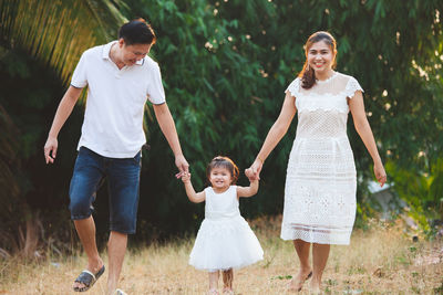 Full length of a smiling young couple in forest