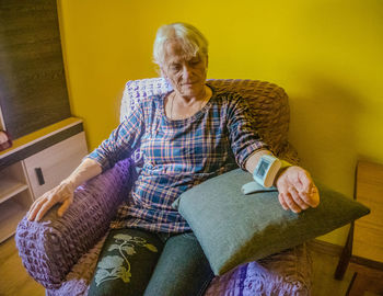 Portrait of young woman sitting on sofa at home