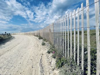 Panoramic view of empty road amidst plants against sky