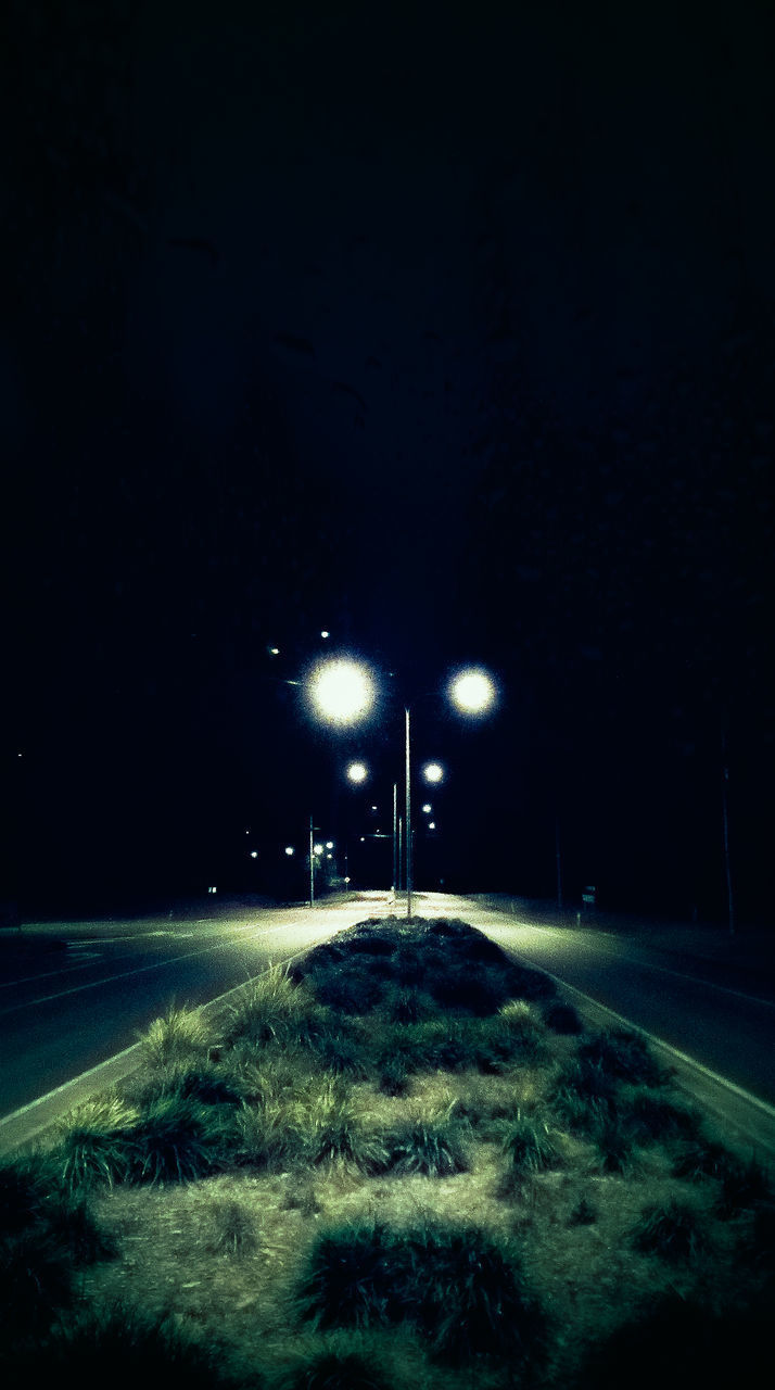 ILLUMINATED STREET LIGHTS ON ROAD IN WINTER