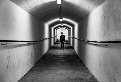 Rear view of woman walking in tunnel