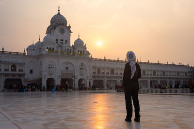 Full length of man at temple against sky during sunset