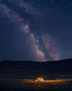 Scenic view of illuminated field against sky at night