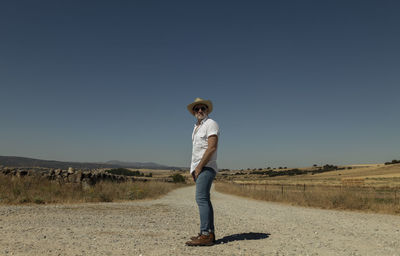 Adult man in cowboy hat on dirt road against sky. castilla y leon, spain