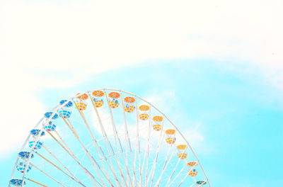 Low angle view of ferris wheel against cloudy sky