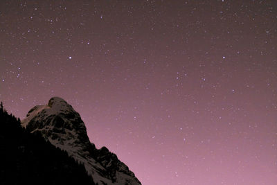 Low angle view of mountain against star field