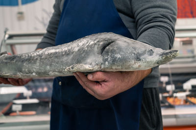 Midsection of man holding fish