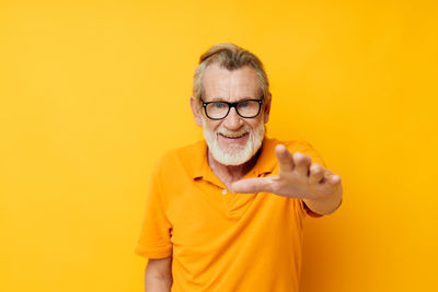 Portrait of young man against yellow background