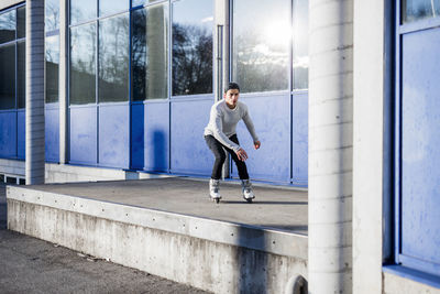 Young man inline skating along a building