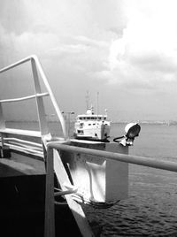 Boats in sea against cloudy sky