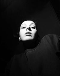 Portrait of a young woman over black background