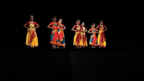 People standing against black background