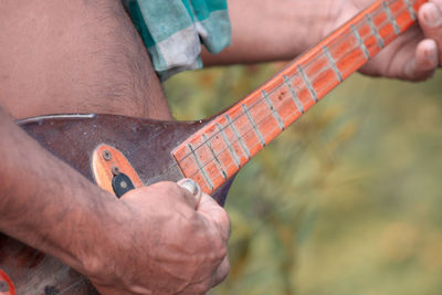 Midsection of man working on metal