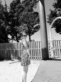 Rear view of woman standing by tree against plants