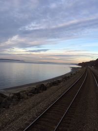 Empty road against cloudy sky