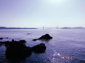 Scenic view of rocks in sea against clear sky