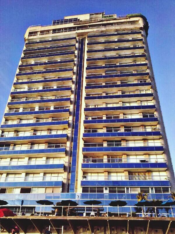 low angle view, architecture, building exterior, built structure, window, building, modern, glass - material, city, sky, office building, day, outdoors, no people, residential building, pattern, residential structure, repetition, reflection, clear sky