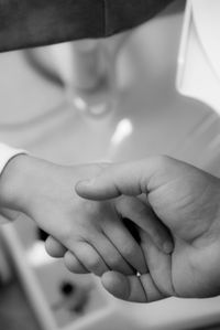 Cropped image of person holding baby hand
