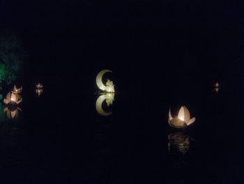 Close-up of illuminated lights against black background